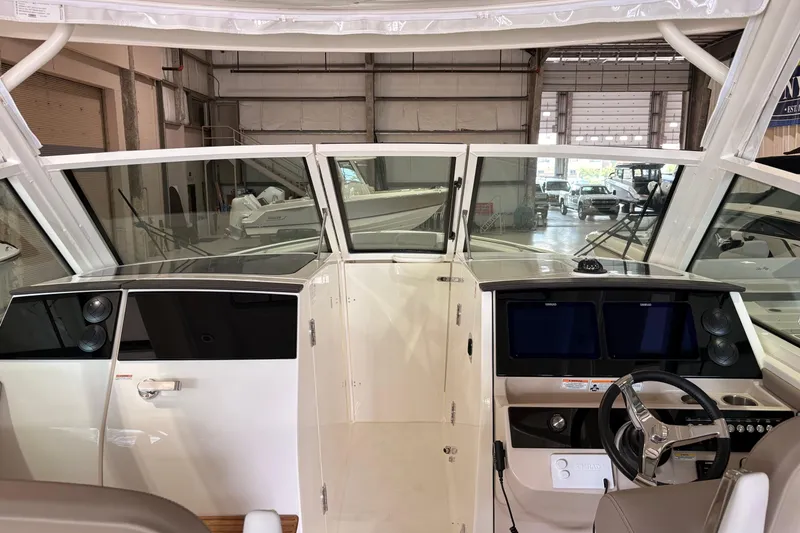 Slide: The Image of Interior view of a 2026 Boston Whaler 330 Vantage boat in a warehouse setting. - 13