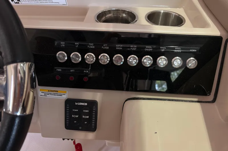 Slide: The Image of Control panel of a 2026 Boston Whaler 330 Vantage boat with labeled switches and cup holders. - 21