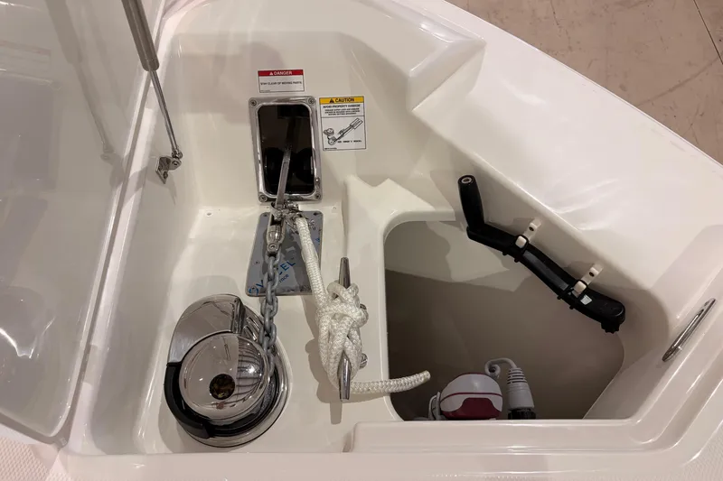 Slide: The Image of Anchor compartment of 2026 Boston Whaler 330 Vantage boat, featuring winch and rope storage. - 23