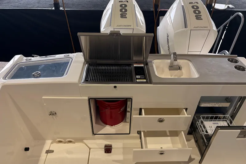 Slide: The Image of 2026 Boston Whaler 330 Vantage boat kitchen with grill, sink, and storage drawers. - 24