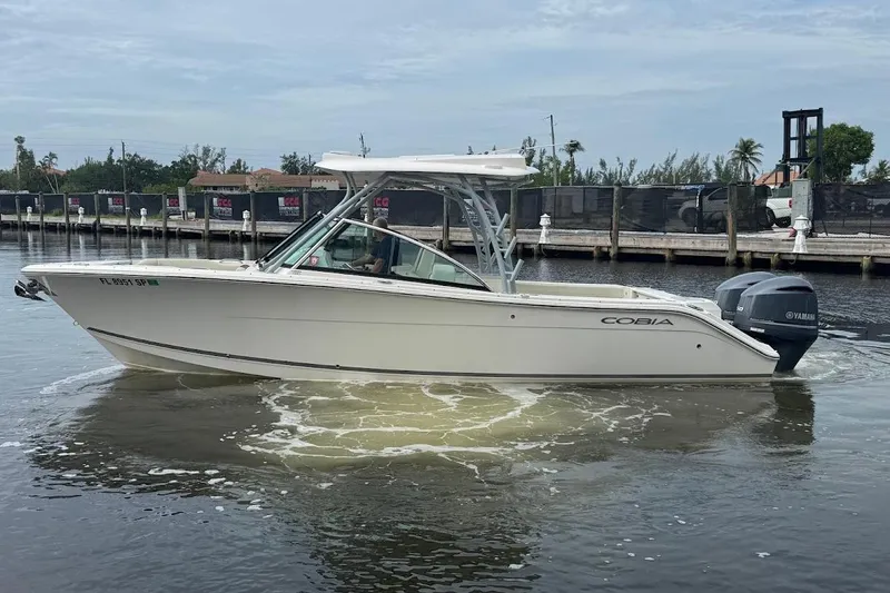 The Image of 2020 Cobia 280 Dual Console boat on water, side view with Yamaha engine. - 0