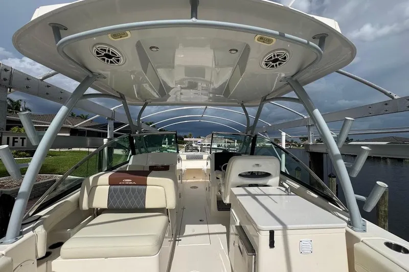 Slide: The Image of 2020 Cobia 280 Dual Console boat interior with seating and storage, docked under cloudy skies. - 42