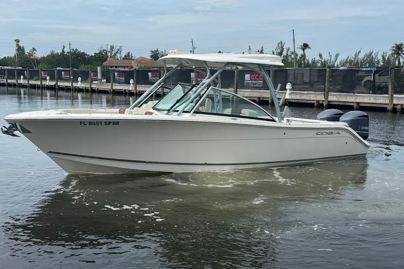 Slide: The Image of 2020 Cobia 280 Dual Console boat on calm water near a dock. - 1