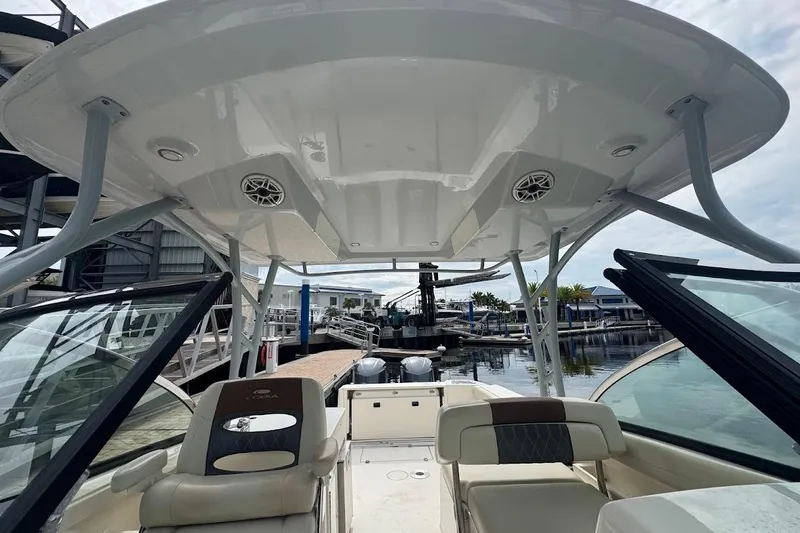 Slide: The Image of 2020 Cobia 280 Dual Console boat interior with seating and open deck at marina. - 10