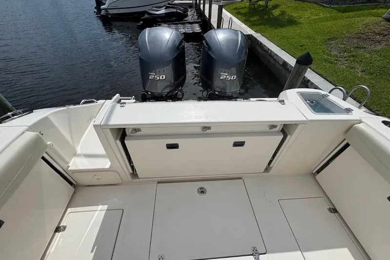 Slide: The Image of 2020 Cobia 280 Dual Console boat with twin Yamaha 250 engines docked by the water. - 38