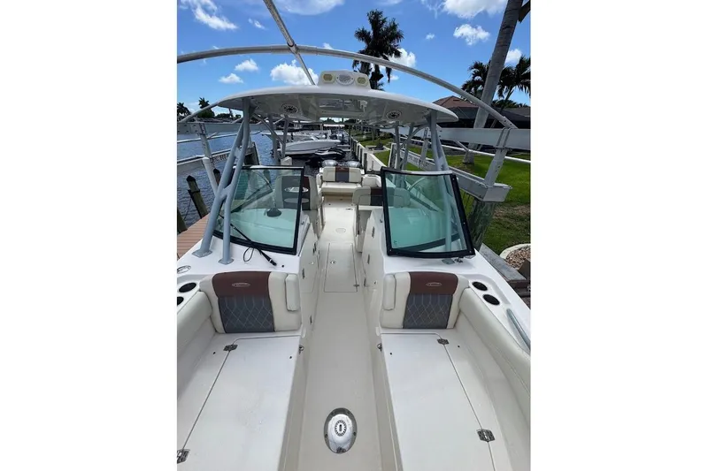 Slide: The Image of 2020 Cobia 280 Dual Console boat docked, featuring spacious seating and sleek design. - 14