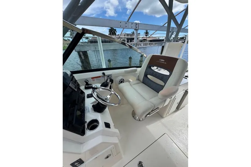 Slide: The Image of 2020 Cobia 280 Dual Console boat interior with steering wheel and captain's chair. - 15