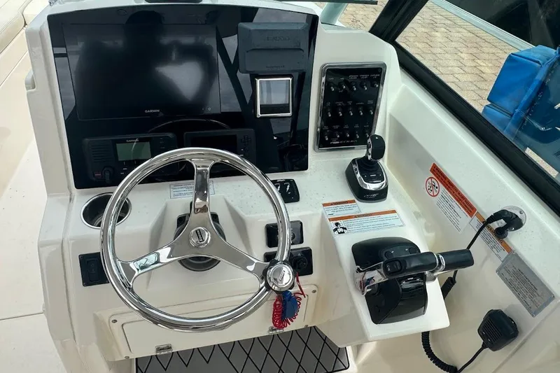 Slide: The Image of Cockpit of 2020 Cobia 280 Dual Console with steering wheel and control panel. - 16