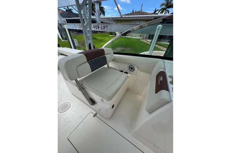 Slide: The Image of 2020 Cobia 280 Dual Console boat interior with cushioned seating and speaker. - 17
