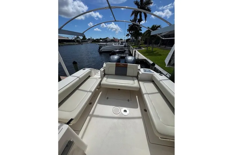 Slide: The Image of 2020 Cobia 280 Dual Console boat interior with seating, docked by a waterfront. - 22