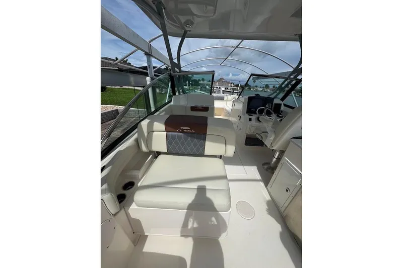Slide: The Image of 2020 Cobia 280 Dual Console boat interior with seating and helm, under clear skies. - 25