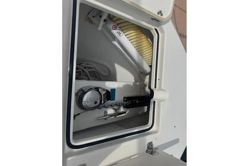 Slide: The Image of Storage compartment of a 2020 Cobia 280 Dual Console boat, featuring ropes and equipment. - 16