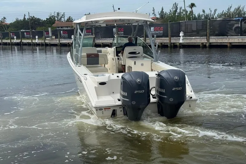 Slide: The Image of 2020 Cobia 280 Dual Console boat with twin Yamaha 250 engines on water. - 27