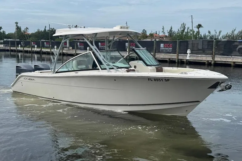 Slide: The Image of 2020 Cobia 280 Dual Console boat on water near a dock. - 3