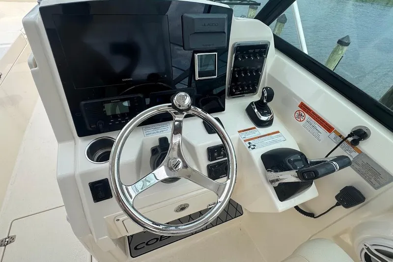 Slide: The Image of 2020 Cobia 280 Dual Console boat helm with steering wheel and control panel. - 23