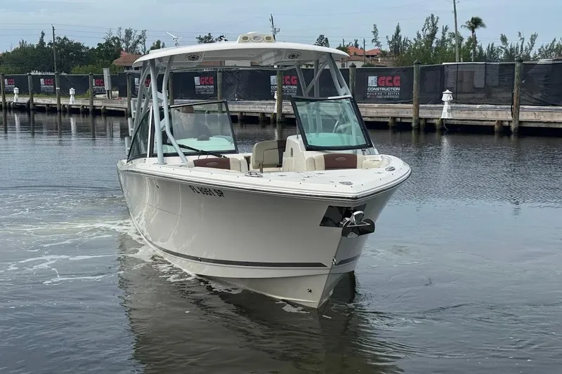 Slide: The Image of 2020 Cobia 280 Dual Console boat on calm water near a dock. - 7