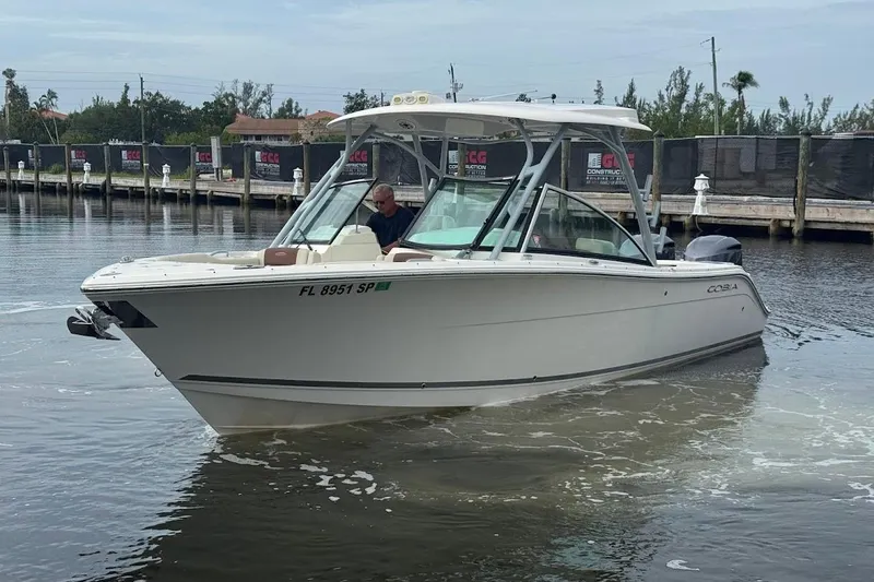 Slide: The Image of 2020 Cobia 280 Dual Console boat navigating a calm marina. - 9