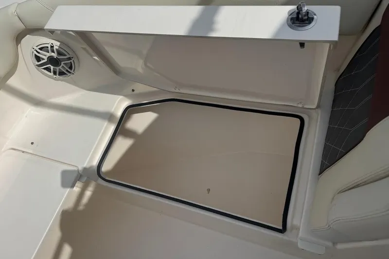 Slide: The Image of 2020 Cobia 280 Dual Console boat interior with storage compartment and speaker. - 19
