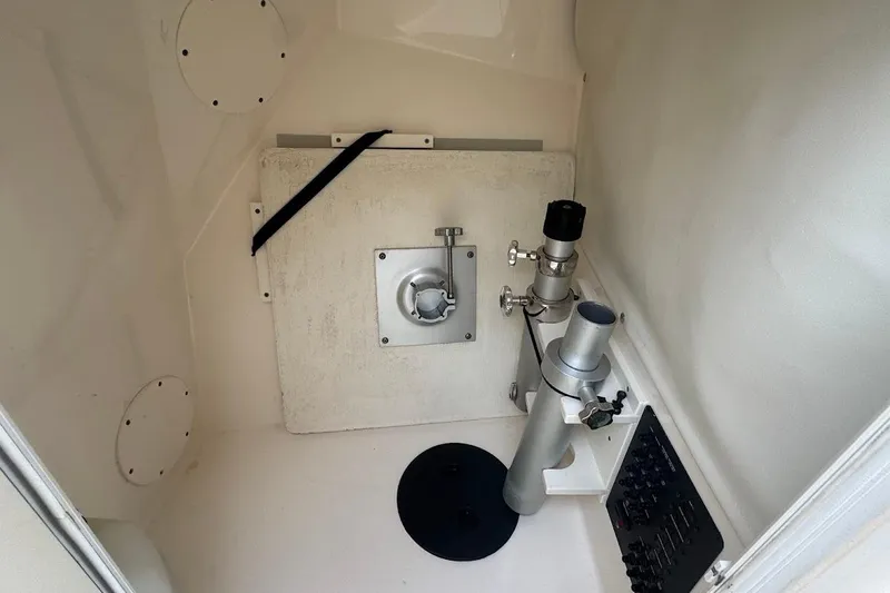 Slide: The Image of Interior of a 2020 Cobia 280 Dual Console boat, featuring storage and plumbing components. - 24