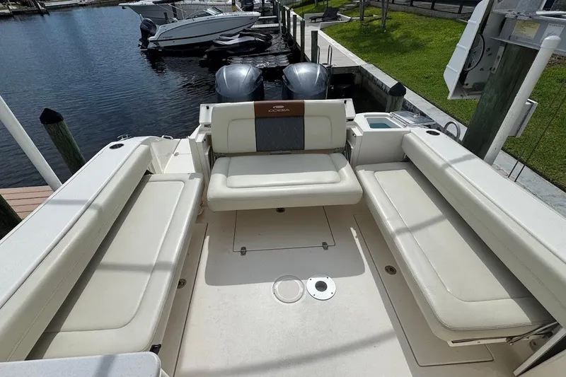 Slide: The Image of 2020 Cobia 280 Dual Console boat interior with seating, docked by the water. - 35