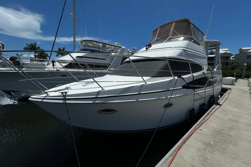 Slide: The Image of 2005 Carver 36 Motor Yacht docked at marina under clear blue sky. - 2
