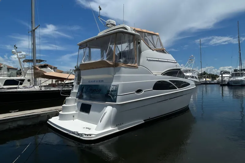 Slide: The Image of 2005 Carver 36 Motor Yacht docked in a marina under a clear blue sky. - 8
