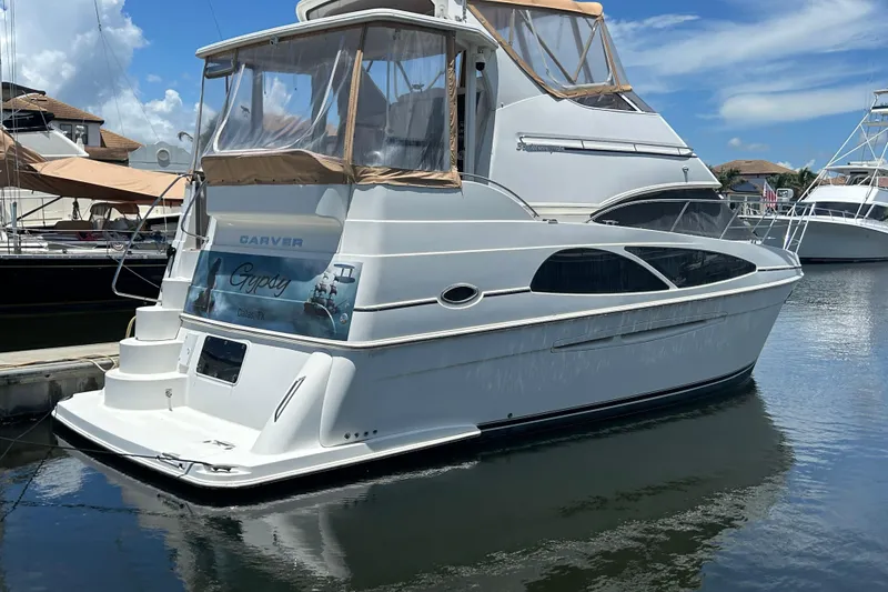 Slide: The Image of 2005 Carver 36 Motor Yacht docked in a marina under a clear blue sky. - 9