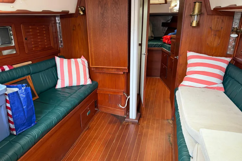 Slide: The Image of Interior of 1989 Sabre 34 MK II sailboat with wood paneling and striped cushions. - 10