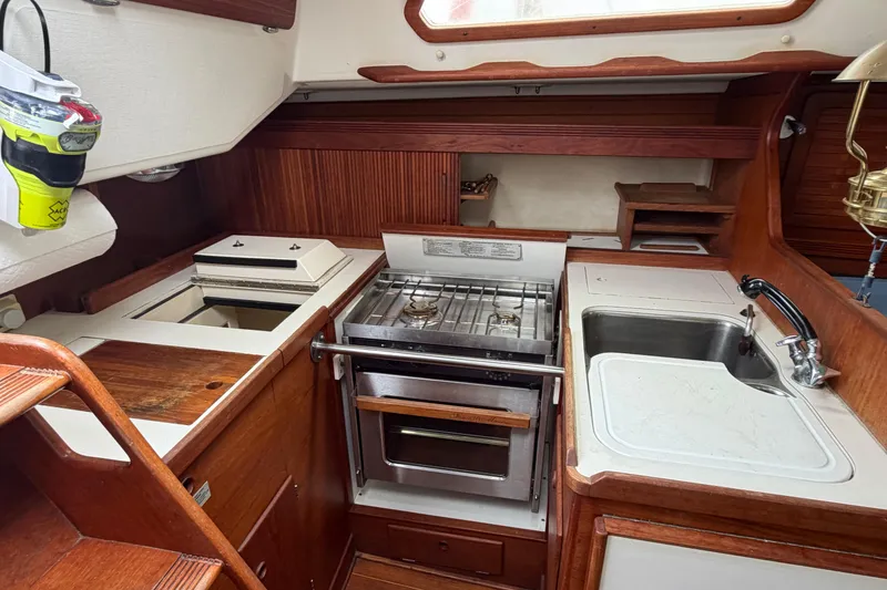 Slide: The Image of 1989 Sabre 34 MK II yacht kitchen with stove, sink, and wooden cabinetry. - 11