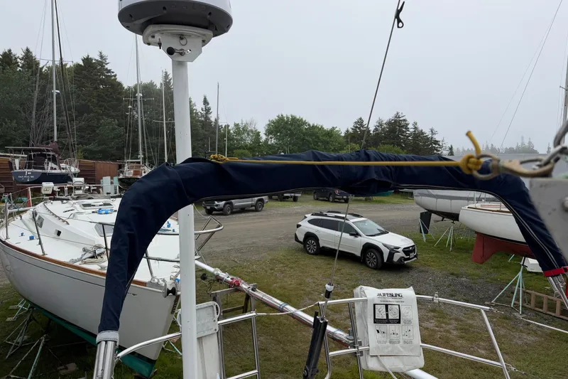 Slide: The Image of 1989 Sabre 34 MK II sailboat in a boatyard with parked cars nearby. - 20
