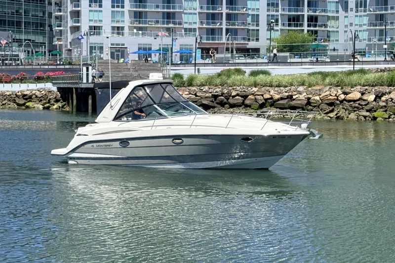 The Image of 2011 Monterey 320 Sport Yacht cruising near modern waterfront buildings. - 0