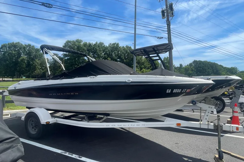 The Image of 2008 Bayliner 195 Bowrider boat on trailer, parked outdoors under clear sky. - 1