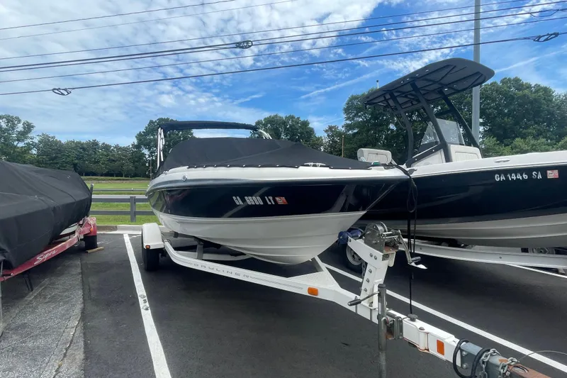Slide: The Image of 2008 Bayliner 195 Bowrider boat on trailer, parked outdoors under a blue sky. - 18