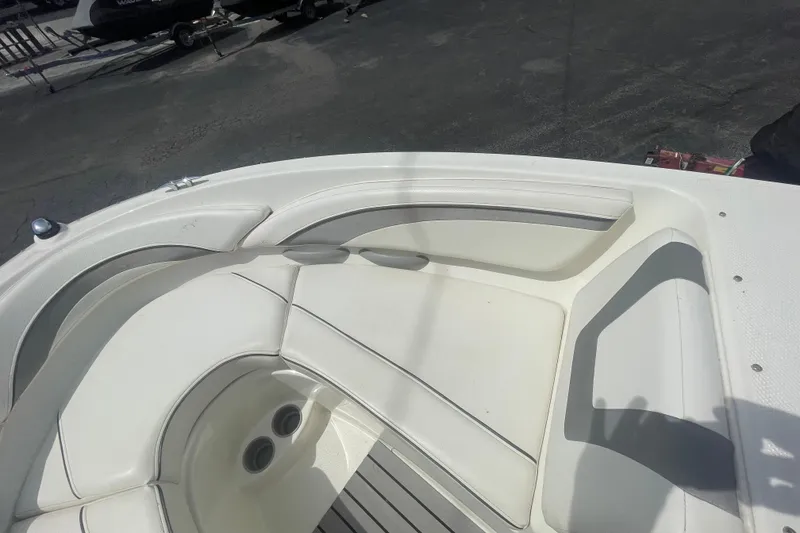 Slide: The Image of 2008 Bayliner 195 Bowrider interior with white cushioned seating and cup holders. - 3