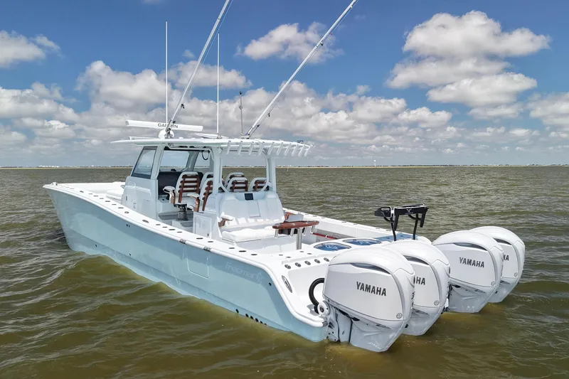 Slide: The Image of 2026 Freeman 43 boat with Yamaha engines on open water under a cloudy sky. - 2