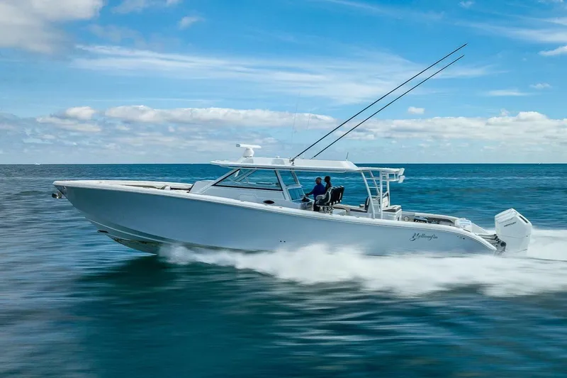 Slide: The Image of 2024 Yellowfin 54 Offshore boat cruising on open water under a clear blue sky. - 11