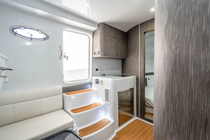 Slide: The Image of 2024 Yellowfin 54 Offshore interior with modern design, featuring seating, steps, and cabinetry. - 14