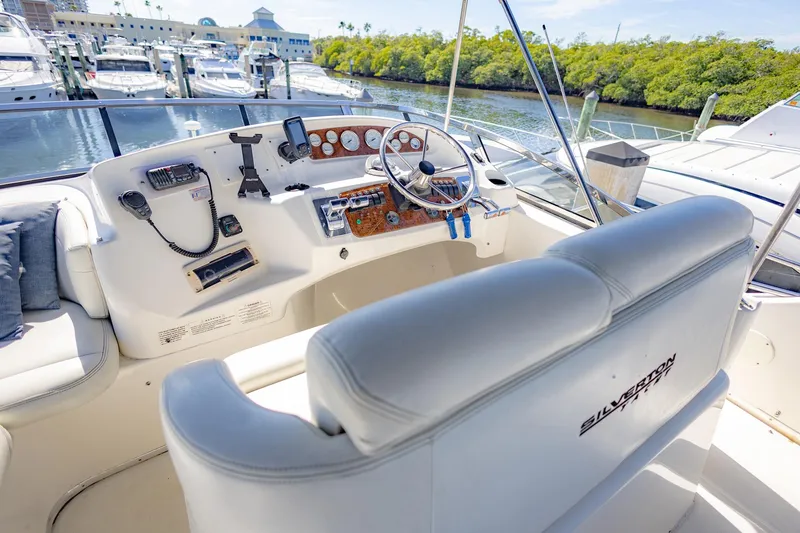 Slide: The Image of 2001 Silverton 410 Sport Bridge yacht helm with marina view. - 62