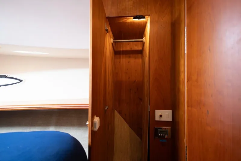 Slide: The Image of Interior of 2001 Silverton 410 Sport Bridge, featuring wooden closet and control panel. - 8