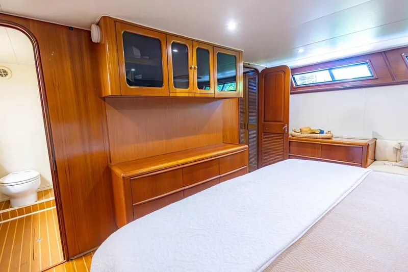 Slide: The Image of Luxurious 1990 Viking Cockpit Motor Yacht interior with wooden cabinetry and cozy bedroom. - 30