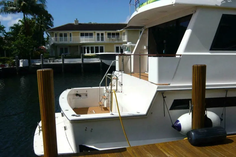 Slide: The Image of 1990 Viking Cockpit Motor Yacht docked near waterfront home, sunny day. - 1