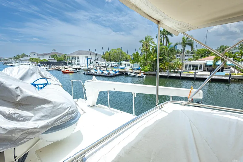 Slide: The Image of 1990 Viking Cockpit Motor Yacht docked at a scenic marina with palm trees. - 49