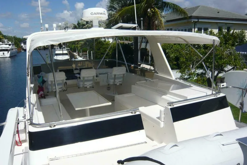 Slide: The Image of 1990 Viking Cockpit Motor Yacht with spacious deck and seating, docked by a canal. - 66