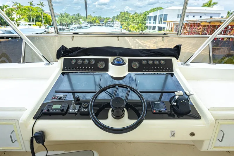 Slide: The Image of Cockpit view of a 1990 Viking Motor Yacht with steering wheel and navigation controls. - 50