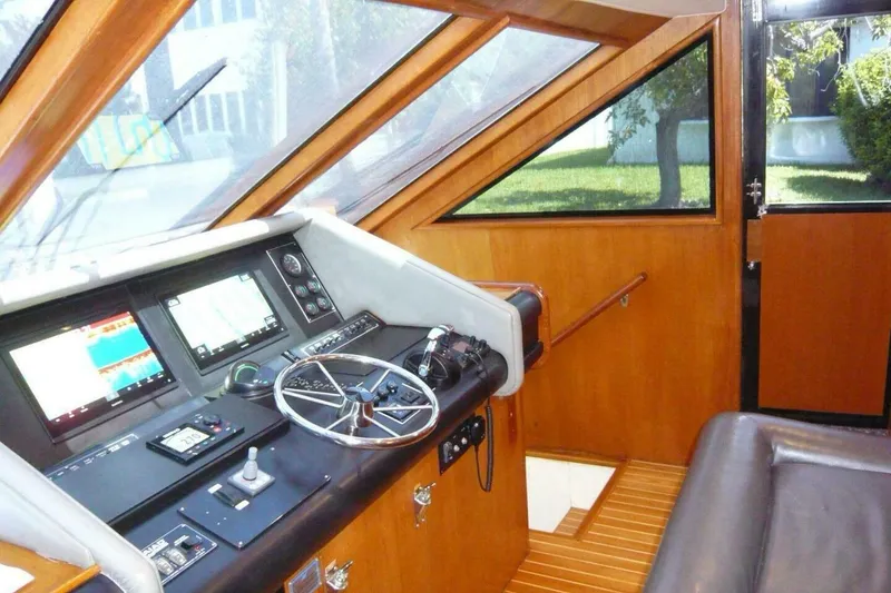 Slide: The Image of Cockpit of 1990 Viking Motor Yacht with modern navigation equipment and wooden interior. - 24