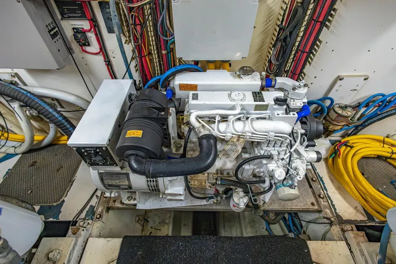 Slide: The Image of Engine room of a 1990 Viking Cockpit Motor Yacht, showcasing detailed machinery and wiring. - 77