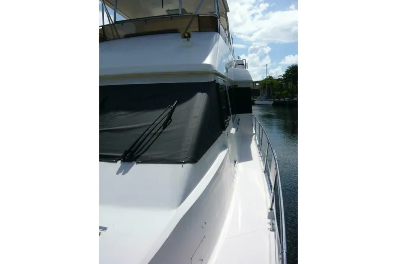 Slide: The Image of 1990 Viking Cockpit Motor Yacht on calm water, showcasing sleek design and spacious deck. - 70