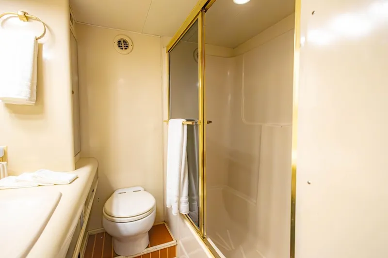 Slide: The Image of Bathroom interior of a 1990 Viking Cockpit Motor Yacht with shower and toilet. - 32