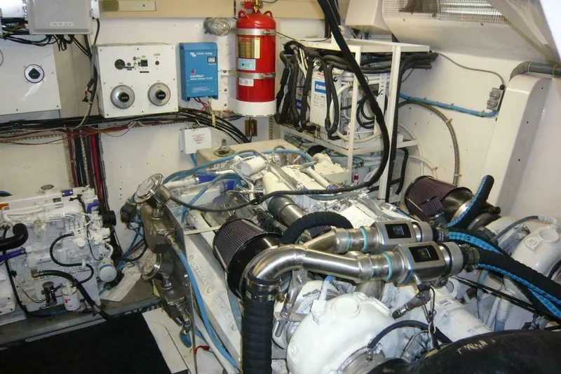 Slide: The Image of Engine room of a 1990 Viking Cockpit Motor Yacht, featuring complex machinery and wiring. - 71