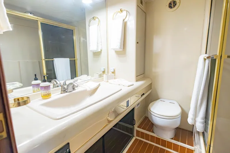 Slide: The Image of Bathroom interior of a 1990 Viking Cockpit Motor Yacht with sink and toilet. - 31